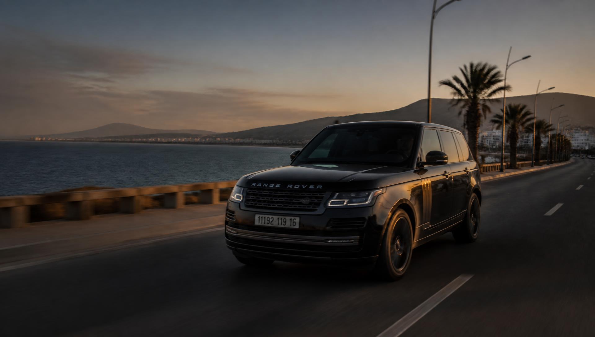 SUV premium sur une route côtière près d'Alger au coucher du soleil